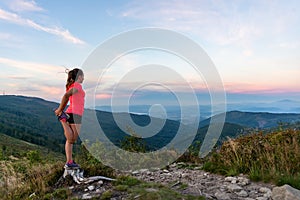 Woman cross country runner quads stretching in mountains at summer photo