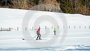 Woman cross country skiing at the foothill of mountain peaks, wide shot