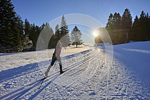 Woman cross-country skiing short before sunset in the Bregenz Forest Mountains