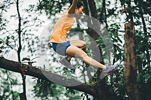 woman cross country trail running in forest