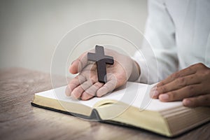 Woman with  cross  in hands praying for blessing from god  in the morning, spirituality and religion