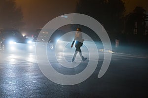 Woman crossing road in fog