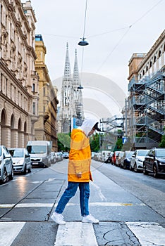 woman crossing street old church towers on background