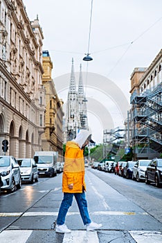 woman crossing street old church towers on background