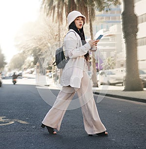 Woman crossing street with phone, walking in city and travel with location app, social media and streetwear. Influencer