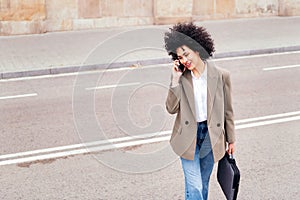 woman crossing the street talking by mobile phone
