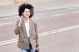 woman crossing the street and talking by phone