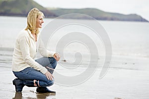 Woman crouching on beach photo