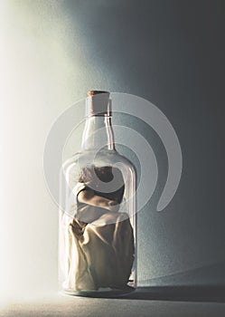 Woman crouching inside a glass bottle photo