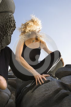 Woman crouching on rocks. photo