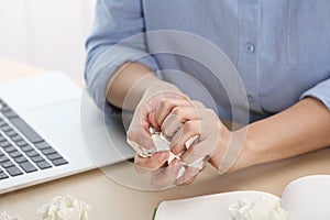 Woman crumpling paper at table, closeup.  idea