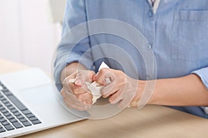 Woman crumpling paper at table. Generating idea