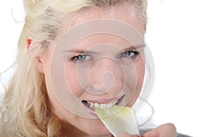 Woman crunching a leaf of endive