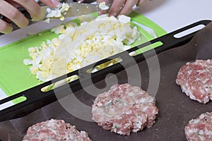 Woman crushes boiled chicken eggs. Minced meat steaks with potatoes, eggs and cheese. Cooking steps and ingredients