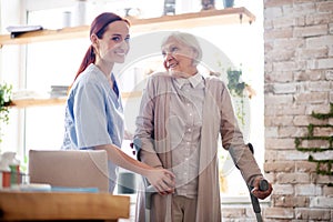 Woman with crutches smiling while talking to caregiver