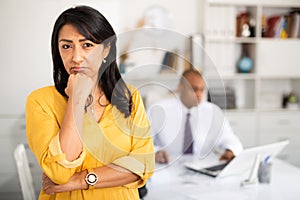 Woman crying standing in office with director behind