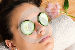 Woman with cucumber slices on eyes.