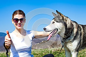 Woman cuddling with husky dog outdoor