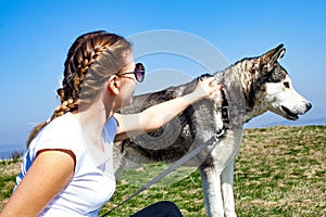 Woman cuddling with husky dog outdoor