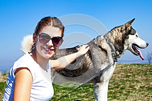 Woman cuddling with husky dog outdoor