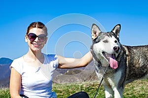 Woman cuddling with husky dog outdoor