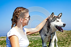 Woman cuddling with husky dog outdoor