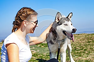 Woman cuddling with husky dog outdoor