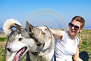 Woman cuddling with husky dog outdoor