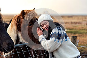 Woman cuddling with Icelandic horse on Iceland road trip