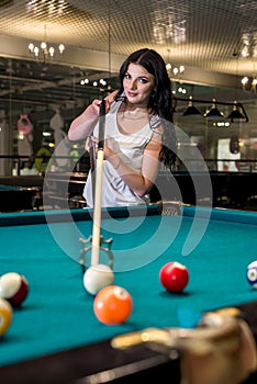 Woman with cue on bridge going hit a ball