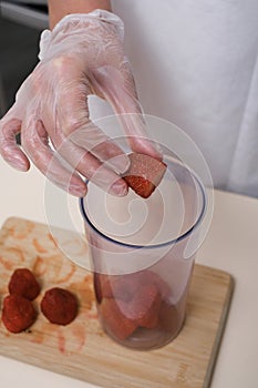 woman in culinary gloves prepares strawberry dessert
