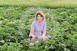 Woman cultivates potatoes on a summer residence