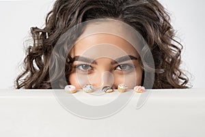 A woman cunningly and intriguingly looks at miniature donuts wanting to eat them