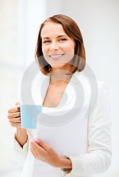 Woman with cup of coffee and folders photo