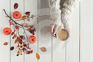 Woman with cup of coffee, leaves, small pumpkins and rowan on white retro wood boards. background. Autumn, fall concept. Flat lay,