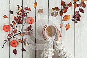 Woman with cup of coffee, leaves, small pumpkins and rowan on white retro wood boards. background. Autumn, fall concept. Flat lay,