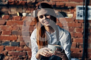 woman with a cup of coffee Near the table waiter service work professionals