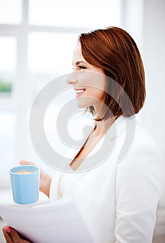 Woman with cup of coffee and papers photo