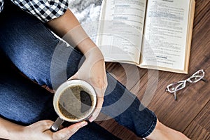 Woman with cup of coffee reading a book