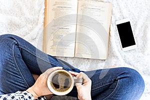 Woman with cup of coffee reading a book