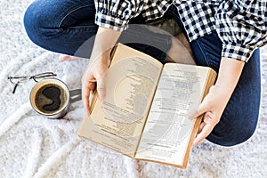 Woman with cup of coffee reading a book