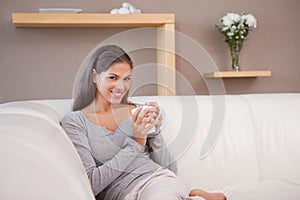 Woman with a cup of coffee on the sofa