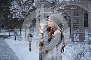 Woman with cup of tea in a park