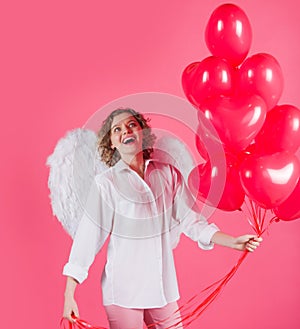 Woman cupid with balloons. Angel girl with red heart shaped balloons. Valentines day advertising.