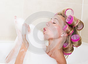 Woman with curlers in bathtub