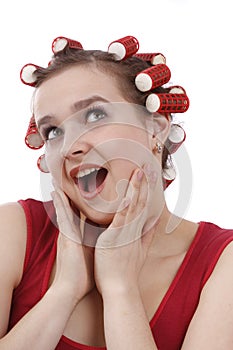 Woman with curlers in her hair looking surprised.