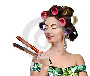 Woman with curlers hold hair curling ironing tool