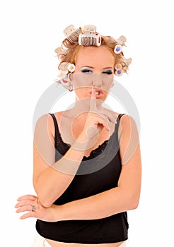 Woman with curlers saying be quiet.