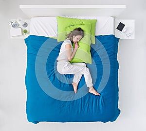 Woman curling up in bed