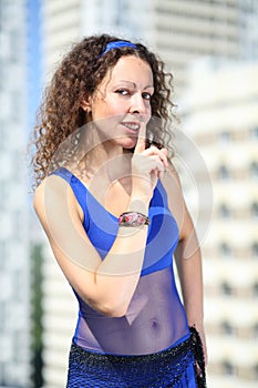 Woman with curly hair in a blue suit and a scarf